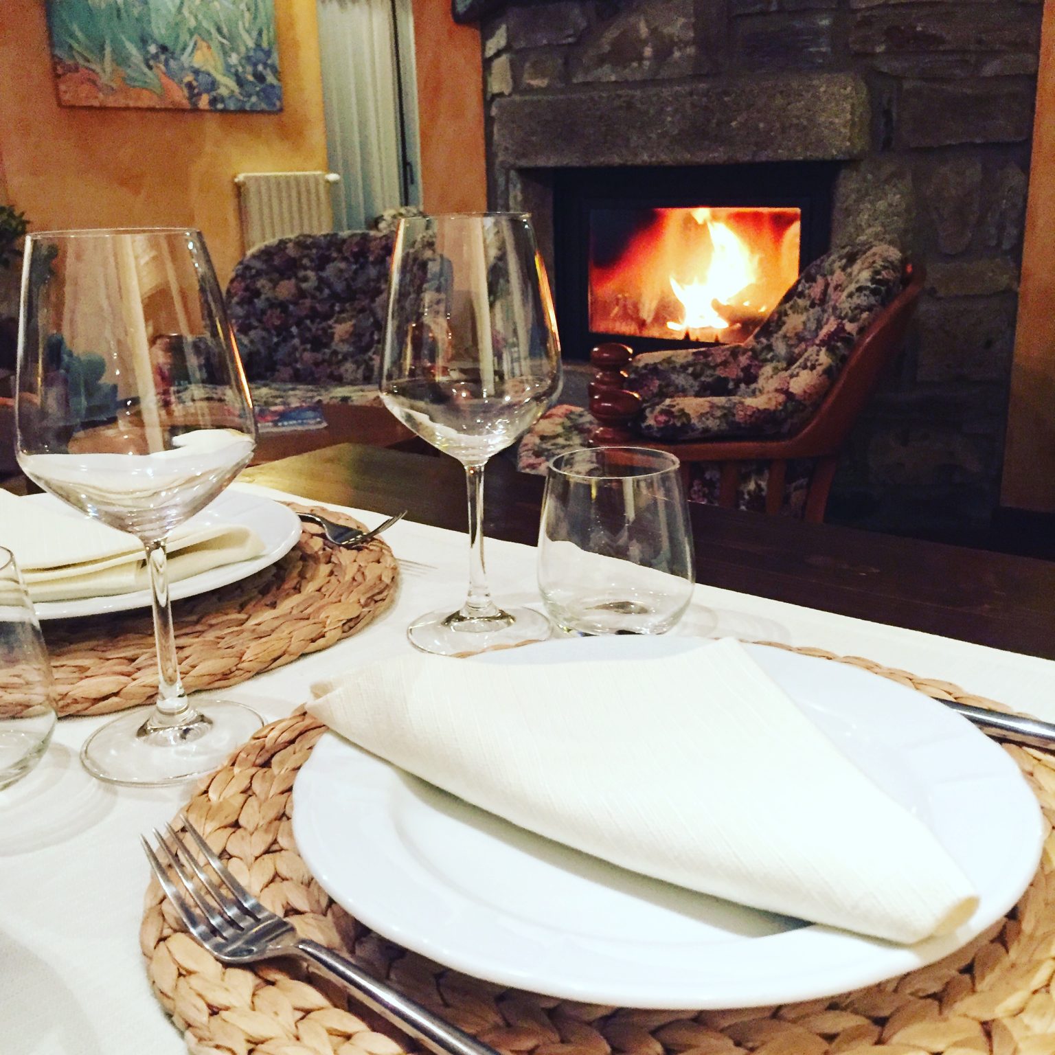 Tavola apparecchiata per cena accanto al camino